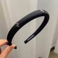 Dettaglio di un cerchietto in raso nero fatto a mano con eleganti fiocchi in metallo argento - Nero