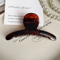 Detail van de 11cm amber haarklem van hars met een gladde afwerking en metalen veerstructuur - Glanzend Karamel