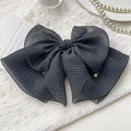 Dettaglio del fermaglio a fiocco in chiffon a pois con eleganti accenti di perle - Polka Dot Nero