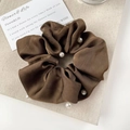 Detailed macro shot of dark brown satin scrunchie with white pearl embellishments - Brown