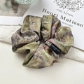 Dettaglio di scrunchie in raso stile pittura a olio con etichetta tessuta decorativa - Scrunchie / Verde Militare