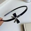 Dettaglio di un cerchietto nero lucido con un elegante fiocco bicolore bianco e nero - Fiocco Nero
