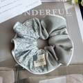 Dettaglio di scrunchie in seta floreale con bottone decorativo ed estetica vintage - Fiori Verdi