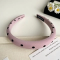 Détail d'un serre-tête rose à pois en velours avec une étiquette de fabrication artisanale - Rose Petit Pois