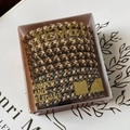 Detalle de gomas de pelo trenzadas de alta elasticidad en tonos neutros en estuche claro - Colores café