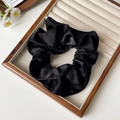 Elegant black satin scrunchie with silk texture on wooden jewelry display tray - Black