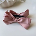 Dettaglio del fermaglio a fiocco in raso rosa con trama elegante a strati di tessuto - molletta a banana / Rosa