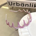 Dettaglio del cerchietto ondulato in acetato rosa marmorizzato con denti interni - Rosa