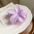 Detail view of a purple marble-patterned frangipani hair claw clip on a white ceramic plate - Light Purple
