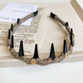 Close-up of headband with black cone spikes and amber water-drop gems on fabric base - Coffee Heart Rhinestone