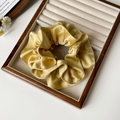 Elegant champagne gold satin scrunchie with silky texture and ruffled design in a gift box - Yellow