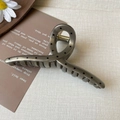Deep gray metal hair claw with black polka dots and gold spring on a cream background - Brown Polka Dot Bar