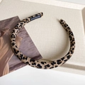 Close-up of leopard print fabric headband with a white handmade label on beige tray - Light Leopard Print - 1cm