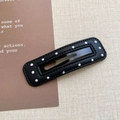 Détail d'une pince BB en cuir noir avec des pois blancs décoratifs sur le bord - Style Rectangulaire Évidé Noir