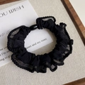 Detail of black double-layered hair scrunchie with sheer lace edges and oval clasp buckle - Black