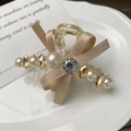 Elegante molletta per capelli con fiocco in seta champagne e perle su piatto di ceramica bianco - Champagne