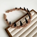 Dettaglio del cerchietto in lana soffice rosa con design unico a denti di squalo neri - Marrone