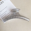 Detail der silbernen Glitzer-Oberfläche und des durchscheinenden Harzes der Haarklammer - Kleiderbügel Modell / Kleiderbügel Stil - Glitzer Silber