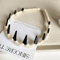 Detalle de diadema de lana crema con púas punk negras y diseño antideslizante con dientes - Blanco