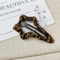 Detail einer sternförmigen Haarklammer mit Leopardenmuster auf minimalistischem Hintergrund - Stern Wassertropfen Leopardenmuster