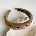Detailed shot of brown velvet headband with black polka dots and Hand Made label - Tan