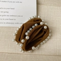 Dettaglio di scrunchie in velluto marrone vintage con bordo di perle bianche - Cuoio