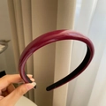 Primo piano di un cerchietto in vernice bordeaux con fodera interna antiscivolo nera - Rosso Scuro