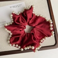 Detalle de coletero de satén burdeos con elegantes perlas blancas y brillo de seda - Rojo