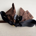 Detail der Haarklammer mit Leopardenmuster-Schleife, schwarzen Bändern und Gold-Metallschnalle - Leoparden-Haarklammer-Stil