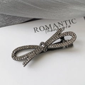 Vue macro de la pince à cheveux noeud en métal noir avec strass champagne foncé - Gris Anthracite-Style Nœud Croisé