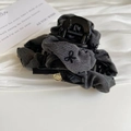 Detail of grey tweed hair claw with black bow embroidery and a golden butterfly charm - Gray Pleated Hair Claw
