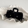 Close-up of black velvet bow hair claw clip with rhinestones on a white shell tray - Medium / Black