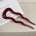 Detailed macro view of the wavy burgundy acetate hair fork with a single crystal accent - Red