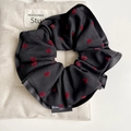 Detalle del coletero negro con corazones rojos flocados sobre fondo de tela de saco - Negro