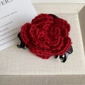 Dettaglio di una molletta per capelli a rosa rossa fatta a maglia con base nera in plastica - Pinza Rosa