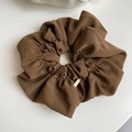 Detail of coffee brown pleated scrunchie with a textured fabric and a gold metal tag - Dark Coffee