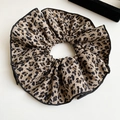 Détail d'un chouchou vintage à imprimé léopard avec passepoil noir sur fond blanc - Léopard - Simple couche