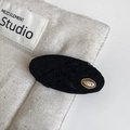 Close-up of black fabric hair clip with a gold oval love metal charm in vintage style - BB Clips / Black