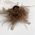 Dettaglio della pinza per capelli con piume marroni e nastro di raso su vassoio - Marrone
