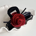 Details einer eleganten burgunderroten Rosen-Haarklammer mit Samtbesatz auf Schale - Rot