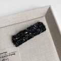 Detailed view of black and white knitted texture on a plush rectangle hair clip accessory - Black Bar Style