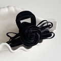 Detail der eleganten schwarzen Samt-Haarklammer mit 3D-Rose und Schleifenbändern - Schwarz