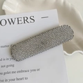 Détail macro d'une pince à cheveux de luxe ornée de cristaux de strass brillants - Argenté