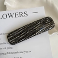 Détail d'une barrette rectangulaire avec strass gris foncé sur une carte blanche - Noir