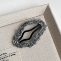 Close-up of soft plush dark grey hair clip with cozy fuzzy texture on fabric tray - Gray Cloud Style