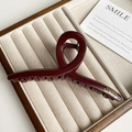 Detail of a large wine red resin hair claw with golden lettering on a jewelry tray - Wine Red Cross Style (FJ-1432)