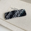 Détail d'une pince à cheveux en laine tricotée avec texture tissée grise et noire - Pince à Cheveux Tricot Noir Gris