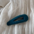 Détail d'une barrette goutte en fausse fourrure vert foncé sur un support en tissu - Bleu