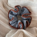 Detail of blue striped fabric scrunchie with soft brown plush trim on cotton background - Brown Edged Striped