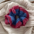 Gros plan détaillé du chouchou en tricot avec fil bleu et rose rouge et paillettes argentées - Bord Rose Rouge